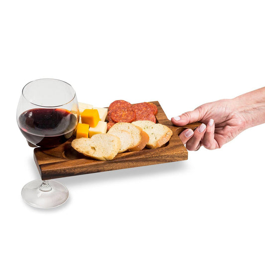 Charcuterie board with wine glass and snacks