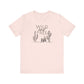 Light pink Wild and Free cactus graphic T-shirt laid flat, offering a soft and trendy option for boho-inspired wardrobes.