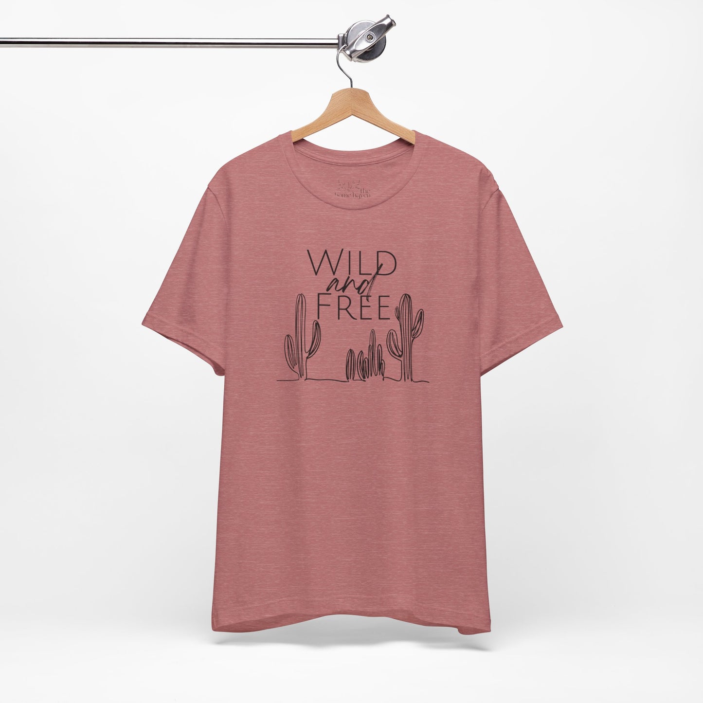 Rust-colored Wild and Free cactus graphic T-shirt on a hanger, showcasing minimalist boho design and soft cotton fabric.