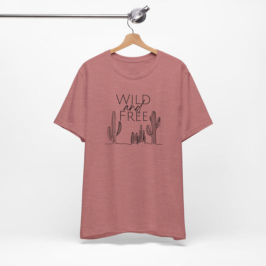 Rust-colored Wild and Free cactus graphic T-shirt on a hanger, showcasing minimalist boho design and soft cotton fabric.