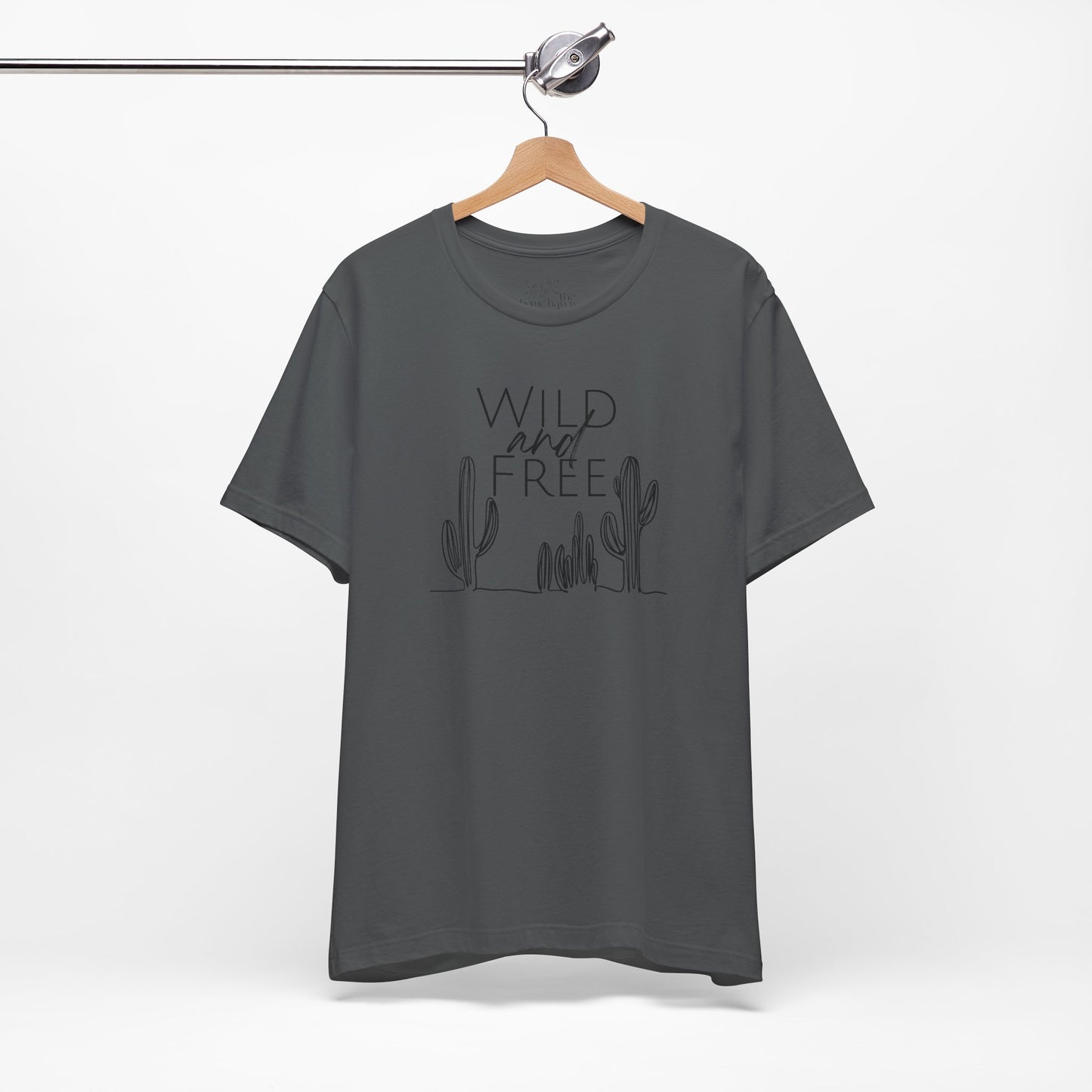 Charcoal Wild and Free cactus graphic T-shirt on a hanger, featuring a subtle boho design for outdoor and casual wear.