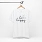 White Be Happy graphic t-shirt with minimalist butterfly design hanging on a wooden hanger for a clean and modern presentation.
