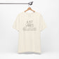 Just Vibes Graphic T-Shirt in cream color with minimalist floral design hanging on a wooden hanger against a white background.