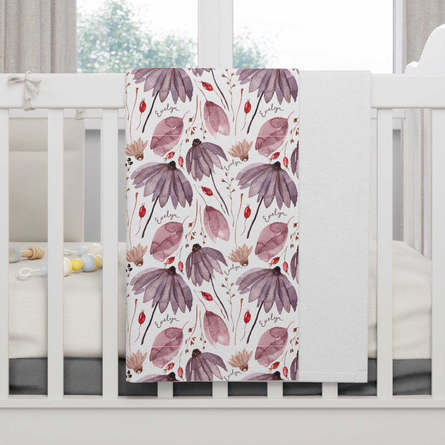 Personalized wildflower baby blanket draped over crib.