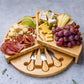 Bamboo cheese board with knives and snacks.
