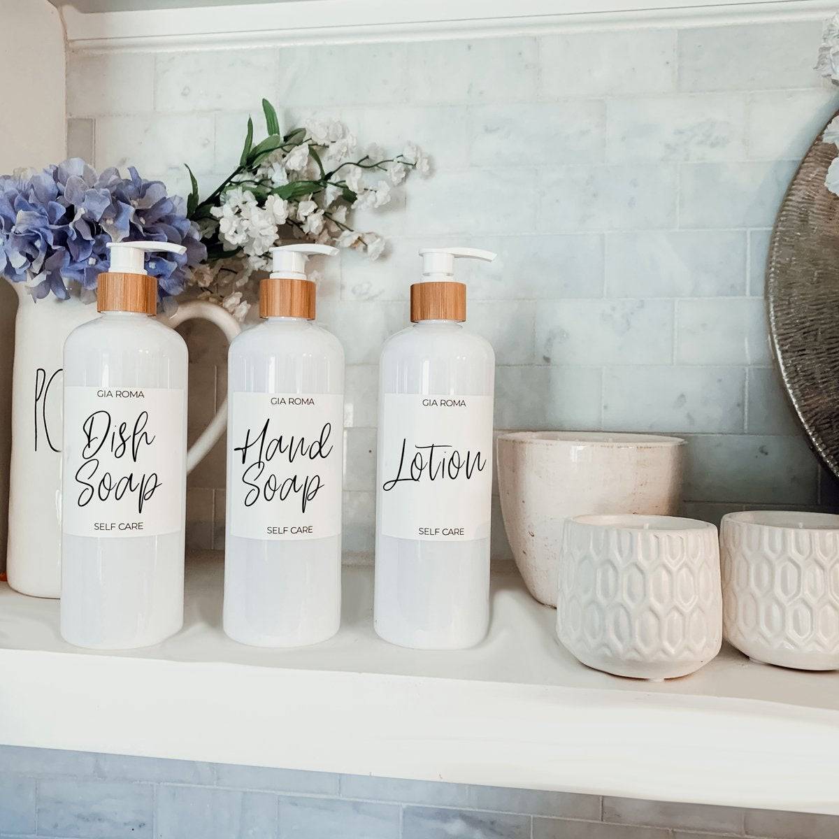 16oz white PET pump bottles labeled dish soap, hand soap, and lotion displayed on a shelf. Elegant bathroom or kitchen dispensers.