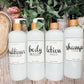 Set of 16oz white PET pump bottles labeled conditioner, body wash, lotion, and shampoo. Stylish dispensers with floral and greenery accents.