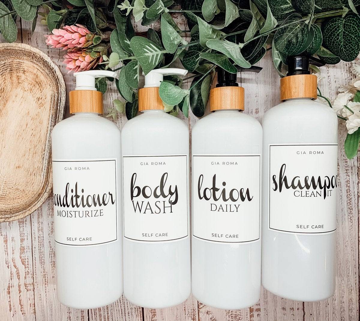 Set of 16oz white PET pump bottles labeled conditioner, body wash, lotion, and shampoo. Stylish dispensers with floral and greenery accents.