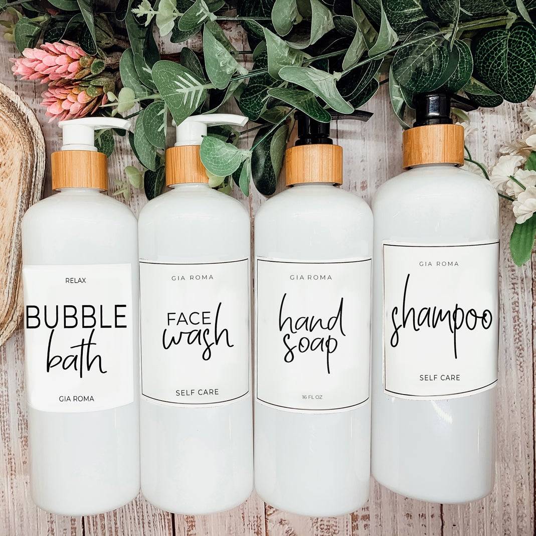 Set of 16oz white PET pump bottles labeled bubble bath, face wash, hand soap, and shampoo. Stylish dispensers with floral and greenery accents.