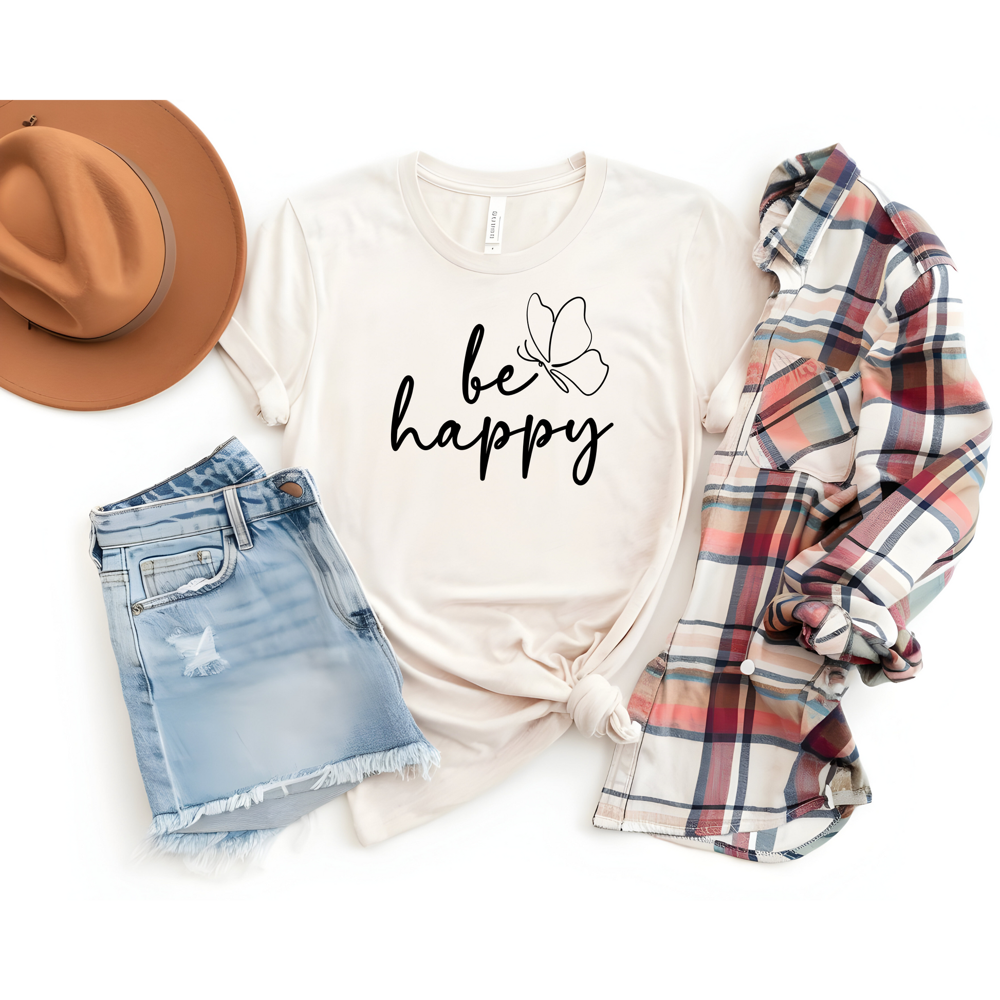Be Happy graphic t-shirt with minimalist butterfly design styled with denim shorts, plaid shirt, and a brown hat for a casual outfit.