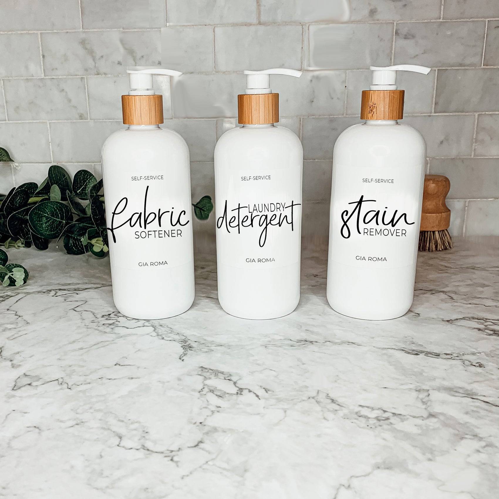 Three 16oz white PET pump bottles labeled fabric softener, laundry detergent, and stain remover. Reusable dispensers for laundry room organization.