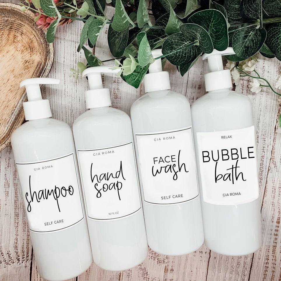 Set of 16oz white PET pump bottles labeled shampoo, hand soap, face wash, and bubble bath. Stylish dispensers with floral and greenery accents.